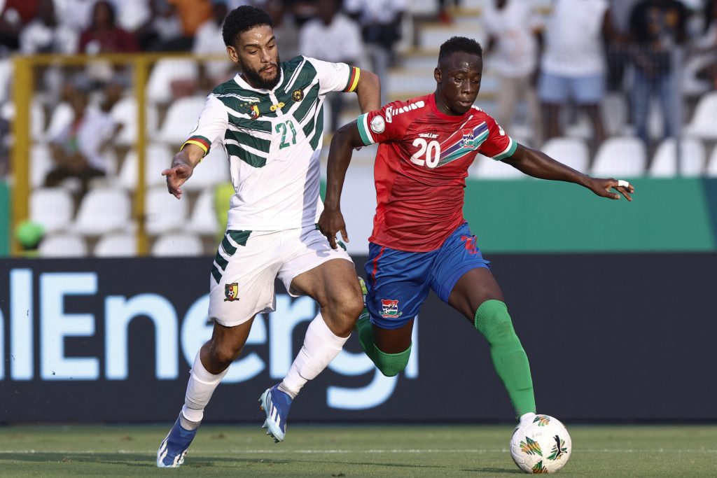 Le défenseur camerounais Jean Charles Castelletto se bat pour le ballon avec l'attaquant gambien Yankuba Minteh au Stade de la Paix à Bouaké le 23 janvier 2024.