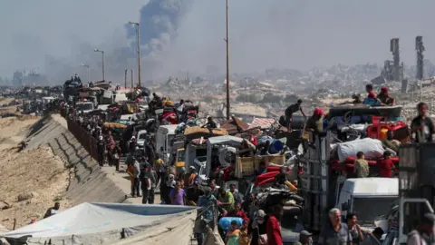 La fumée de Reuters s'élève d'une grève israélienne alors que les Palestiniens déplacés fuient le nord de Gaza, dans la bande centrale de Gaza (14 septembre 2025)