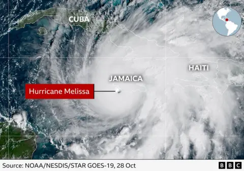 Image satellite montrant l’ouragan Melissa s’approchant de la Jamaïque dans les Caraïbes. L'œil de la tempête est clairement visible, entouré de denses bandes de nuages ​​blancs. La Jamaïque est indiquée près du centre, avec Cuba au nord-ouest et Haïti au nord-est.
