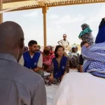 Dans l'est du Tchad, au poste frontière d'Adré, le directeur adjoint de l'OIM, SungAh Lee, a rencontré certaines des familles qui ont fui le conflit au Soudan. Photo : OIM Tchad/2026.