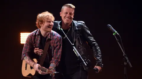 Getty Images L'auteur-compositeur-interprète Ed Sheeran (à gauche) et le rappeur Macklemore se produisent lors du festival de musique iHeartRadio 2014 au MGM Grand Garden Arena le 20 septembre 2014 à Las Vegas, Nevada.