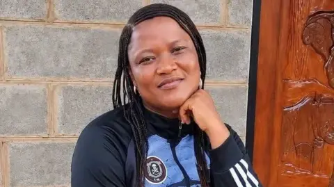 Famille Kekana Itumeleng Kekana est vue souriant avec un maillot de supporter de football