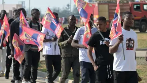 Les partisans de Reuters portent des drapeaux à l'effigie du président Hakainde Hichilema