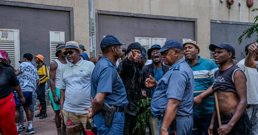Des manifestants anti-immigration se déplacent dans le CBD de Joburg sous la surveillance de la police après l'incendie d'une voiture par la Cour constitutionnelle